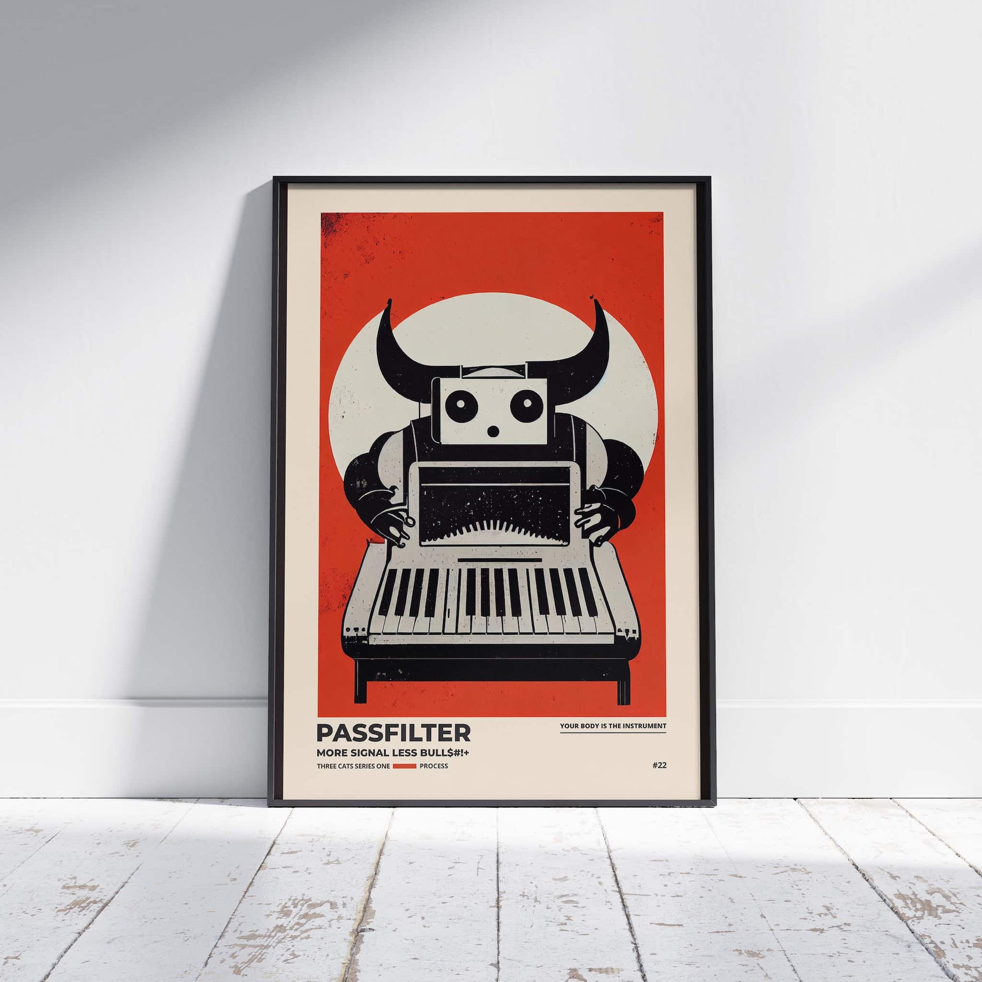 Black framed Passfilter poster sitting on a white wooden floor in a recording studio.